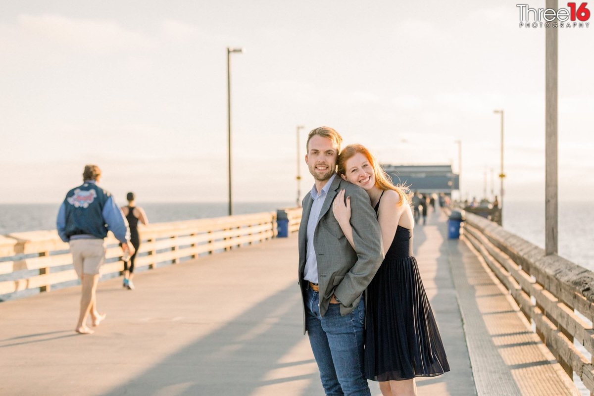 Bride to be embraces her Groom from behind during engagement photo session