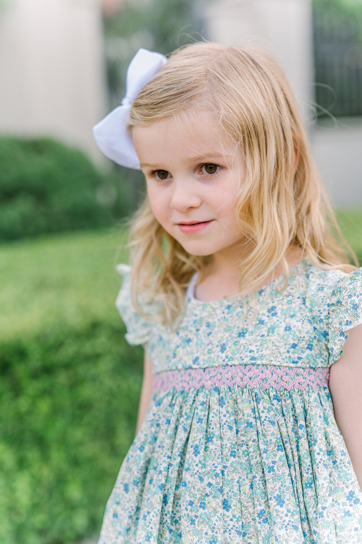 Young girl wearing a floral smocked dress.