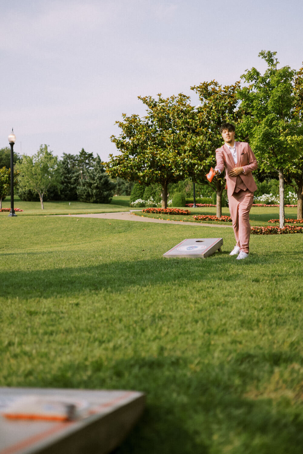 man-in-pink-suit-throwing-cornhole-bag