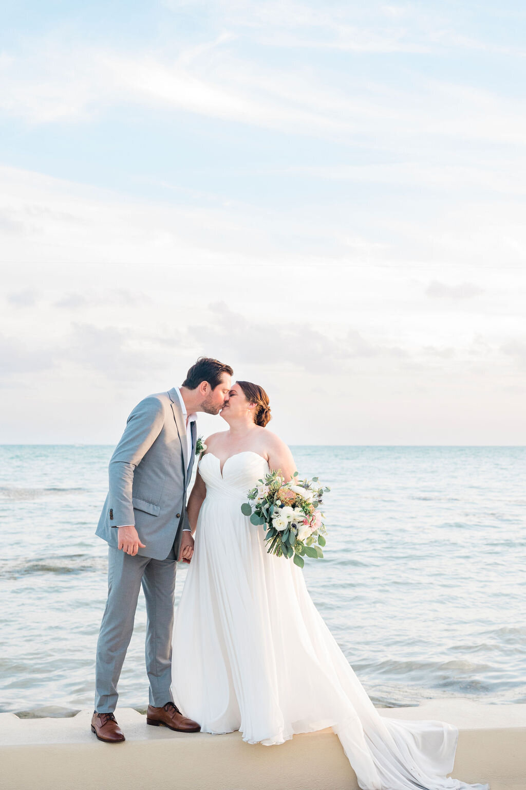 Bride and groom kiss in front of the water at their Key West wedding