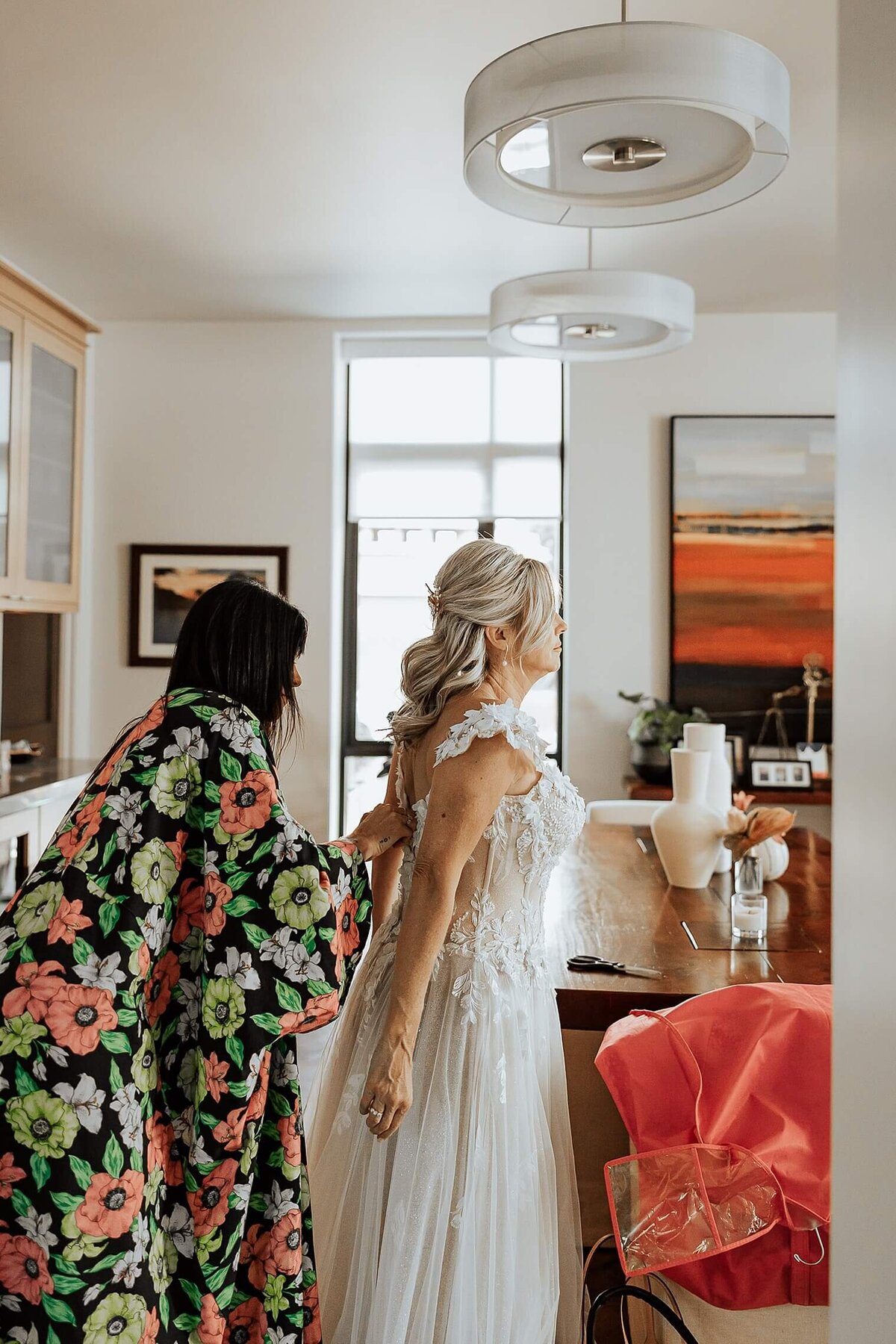 bride getting her dress fixed on her wedding day. Michelle Betz Photography