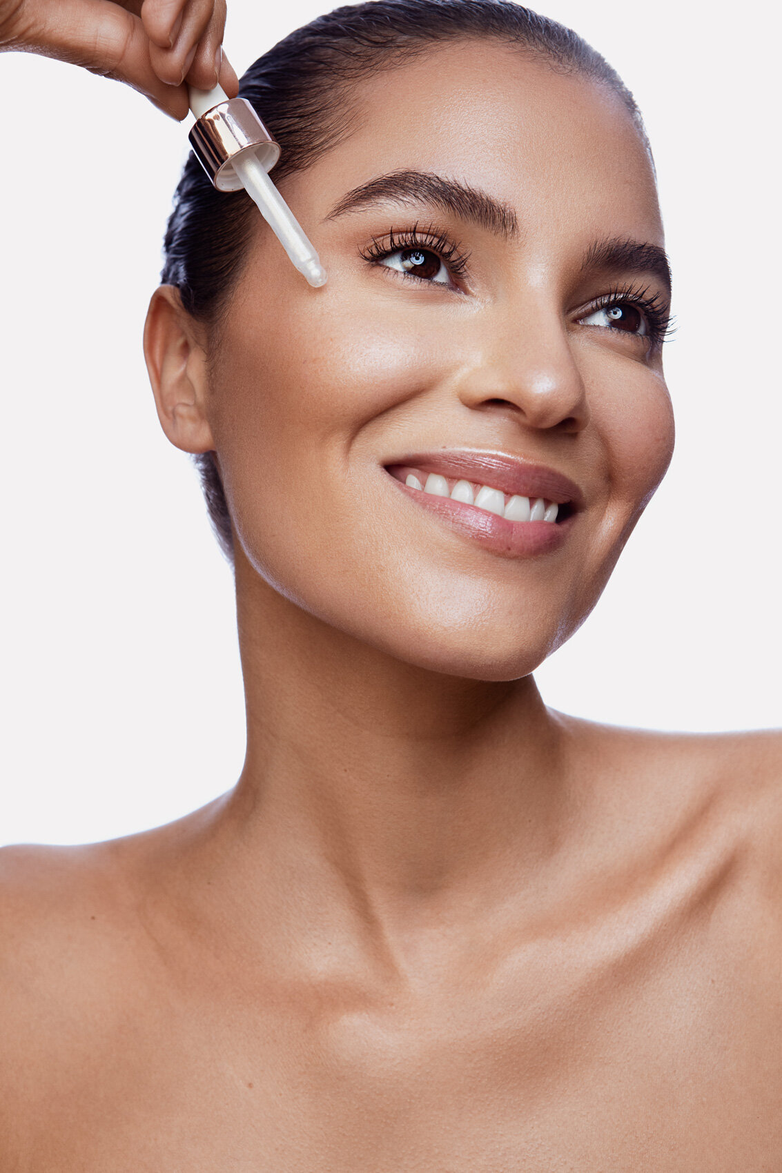 Smiling beauty portrait of a woman with flawless skin, showcasing a natural makeup look, captured by Ylva Erevall.