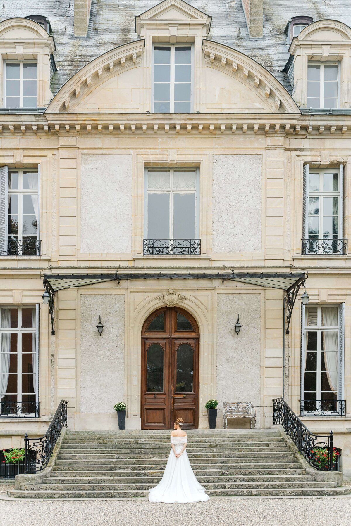 bride in front of the Château de Santeny, facing the chateau and giving her back to the camera