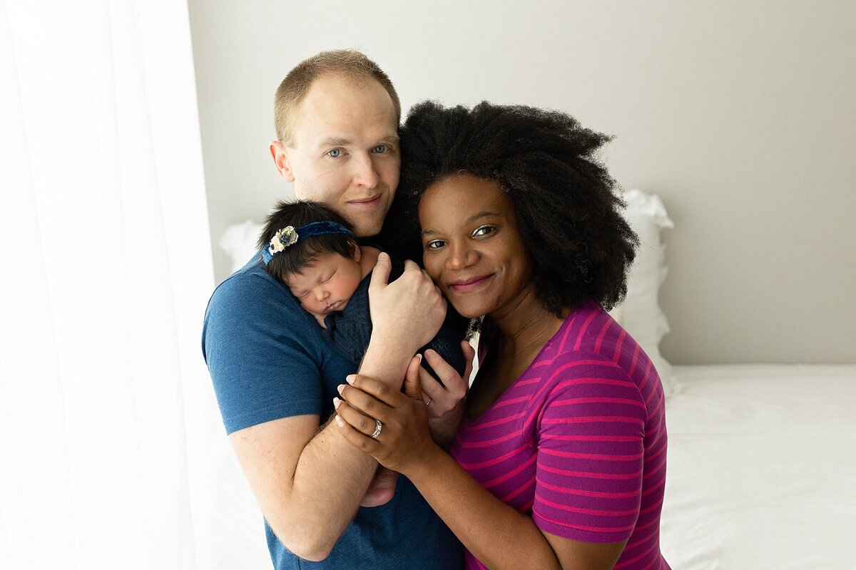 dayton-ohio-newborn-photographer-near-me-amanda-estep-photography-dad-holding-newborn-baby-girl-on-shoulder-and-mom-hugging-close-to-them