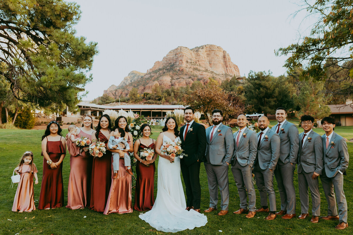 couple stands with bridal party  in sedona arizona wedding