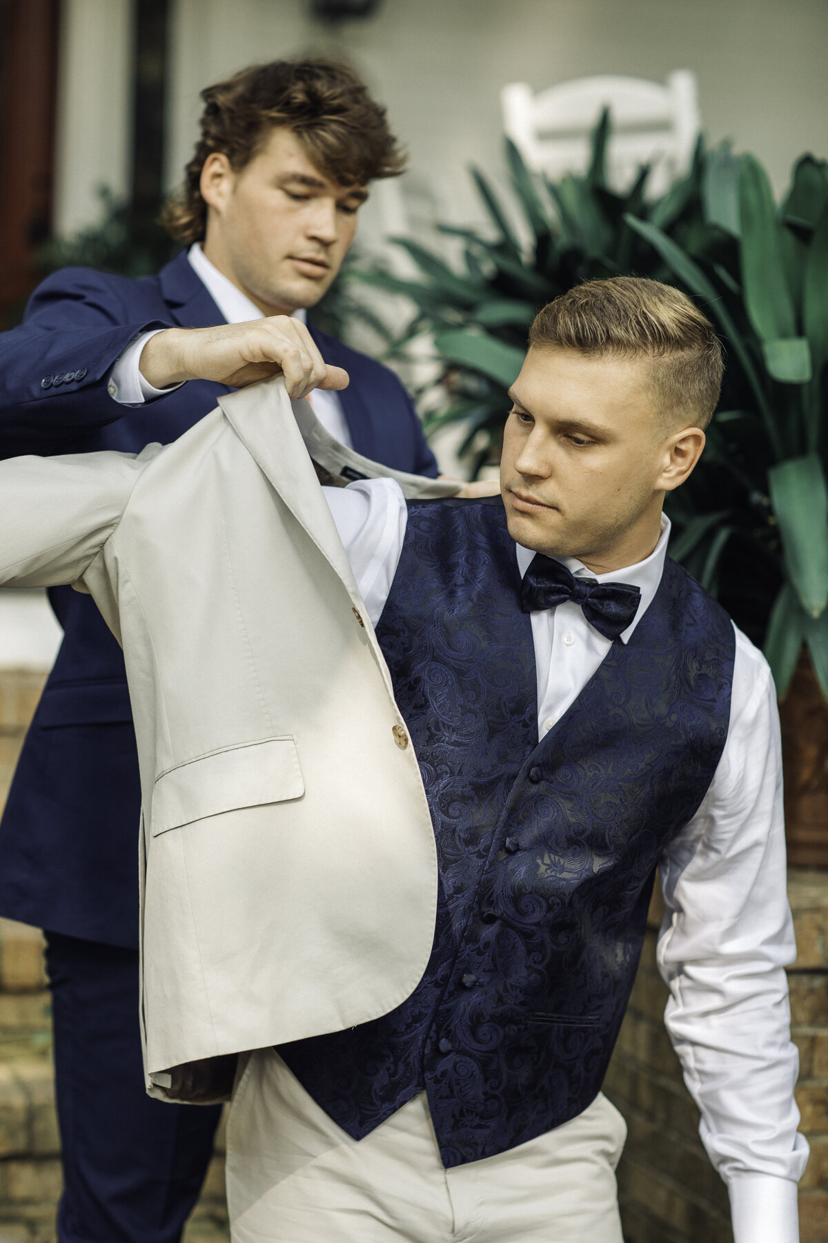Wedding Photograph Of Man Helping Groom Put His Suit On Los Angeles