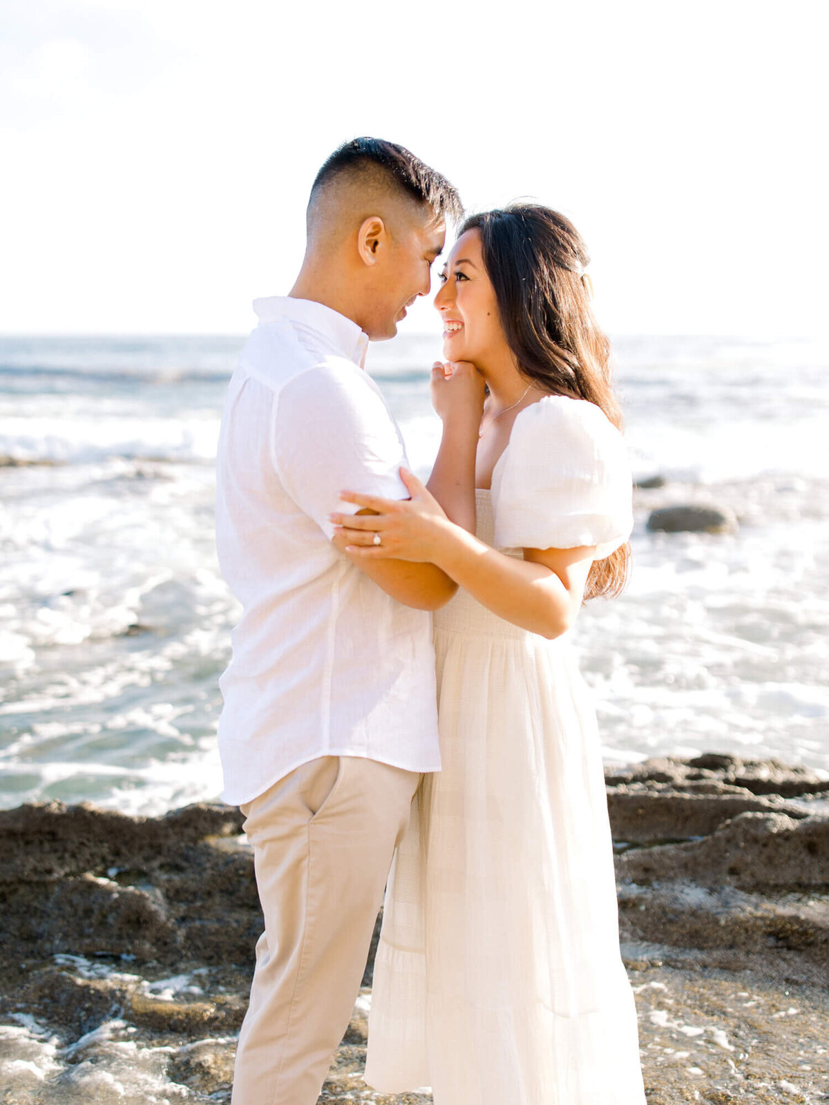 couple looking at each other touching foreheads at laguna beach