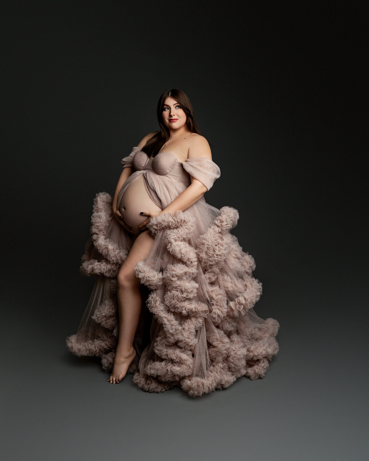Wearing a soft pink dress, she confidently poses for the camera, exuding elegance and natural beauty. Captured by Inland Empire photographer Kaitlyn Dawn Photography.
