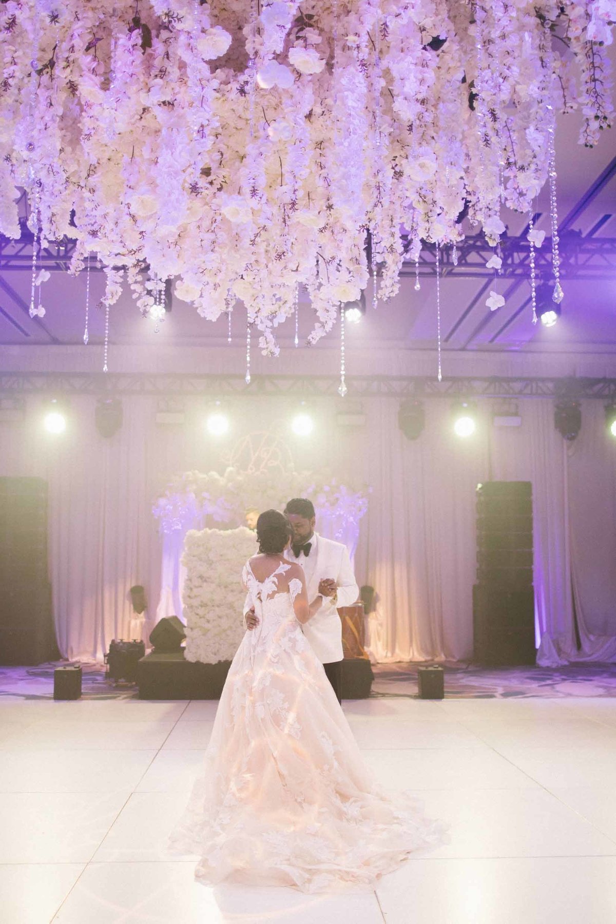 Beautiful white floral chandelier instillation suspended above the dance floor for this luxe ballroom Seattle wedding
