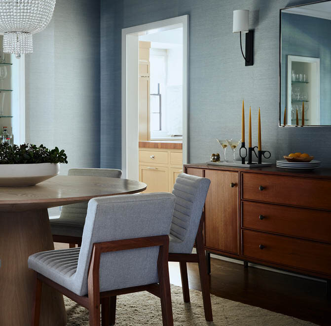 Explore this Hingham dining room with dark blue grasscloth wallcovering, a cerused oak dining table, and a walnut console, showcasing elegant interior design.