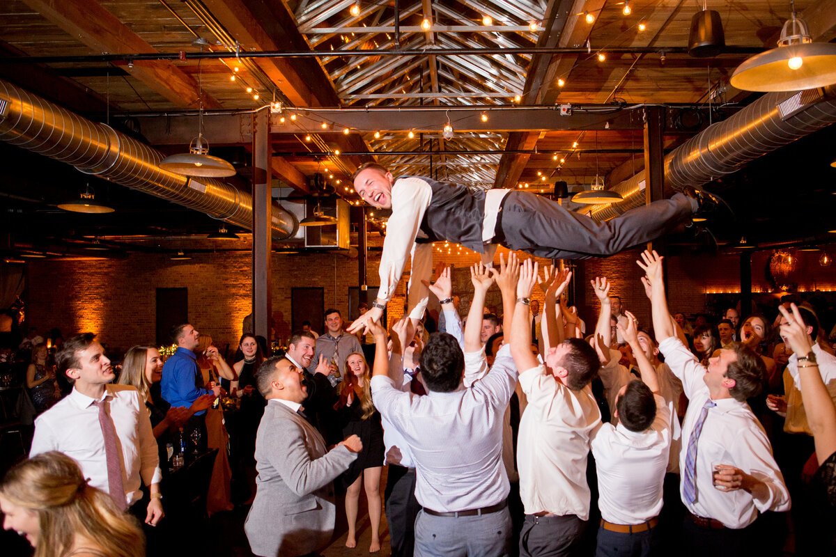 groom is thrown in the air at a Wedding at Morgan Manufacturing in Chicago