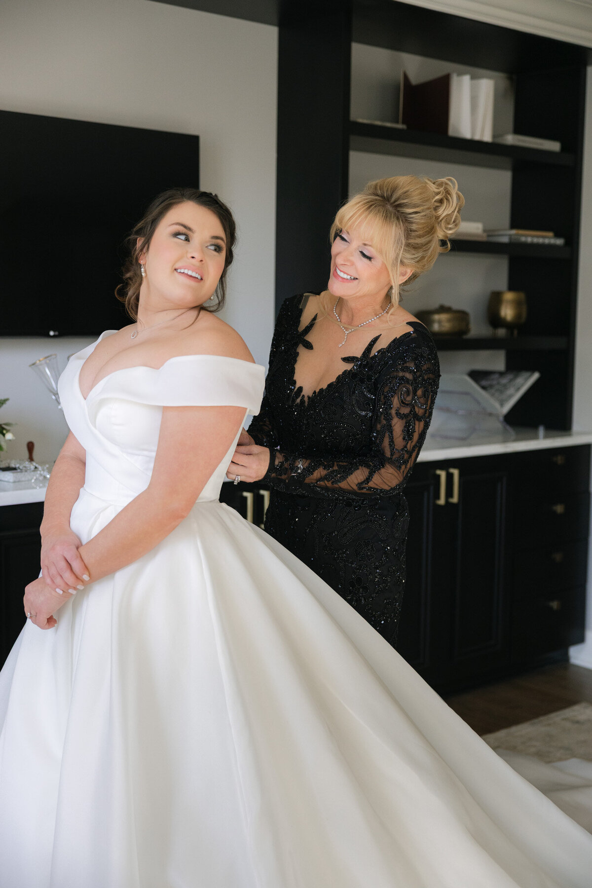 bride getting dressed with help from her mother at The Adolphus in Dallas, capturing a classic and heartfelt wedding preparation moment.