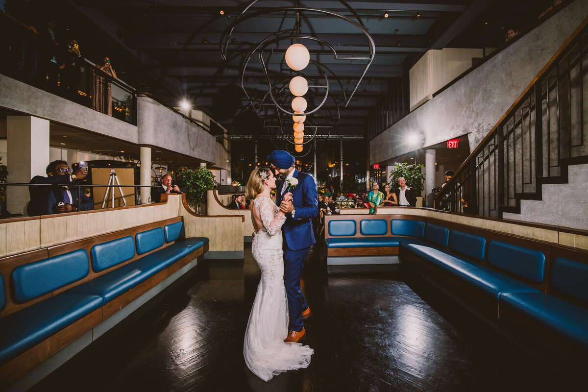 A sikh groom and a white bride in a white dress having their first dance at fabourg restaurant in montclair nj