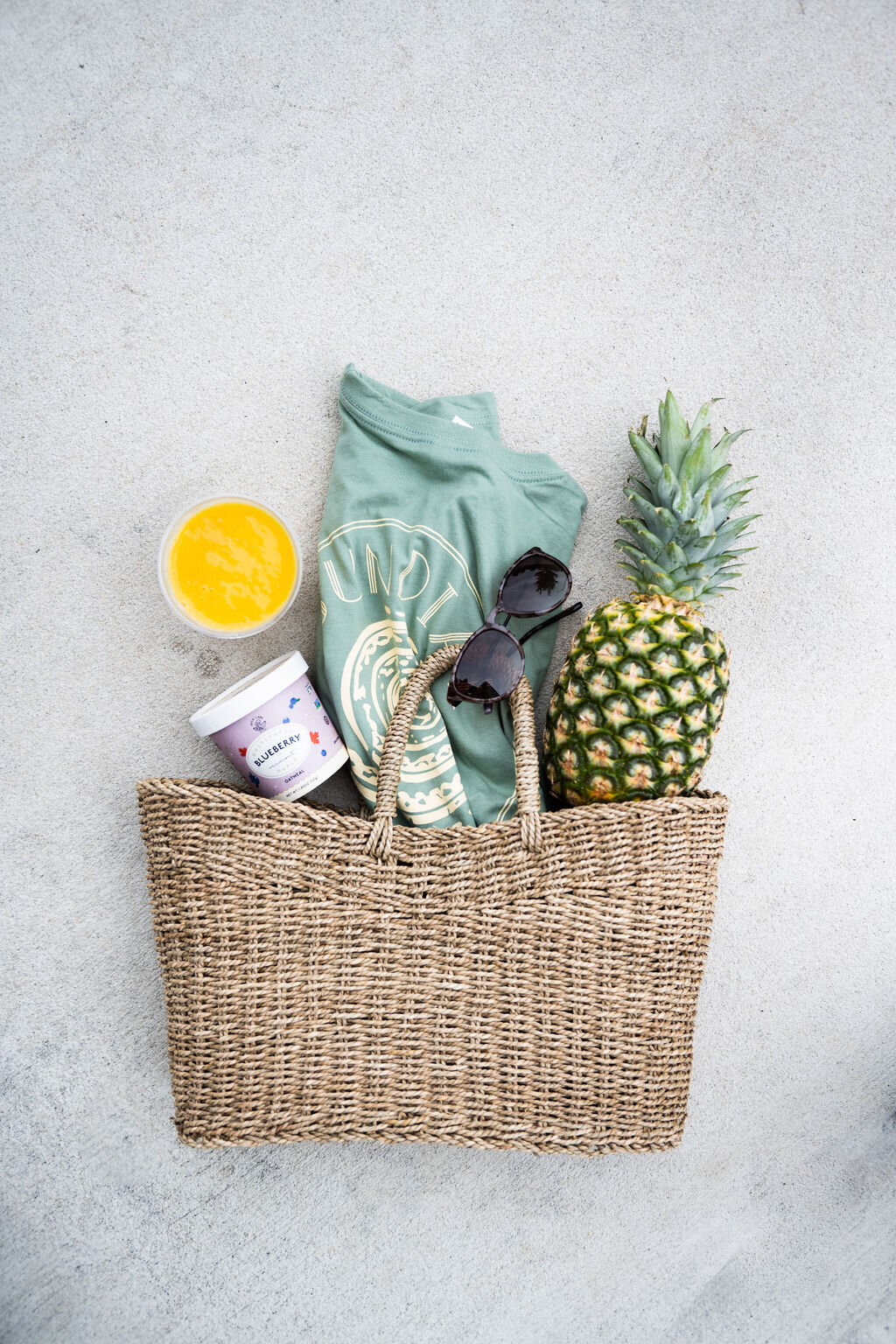 beach bag with sundial  tee shirt, sunglasses, and pineapple