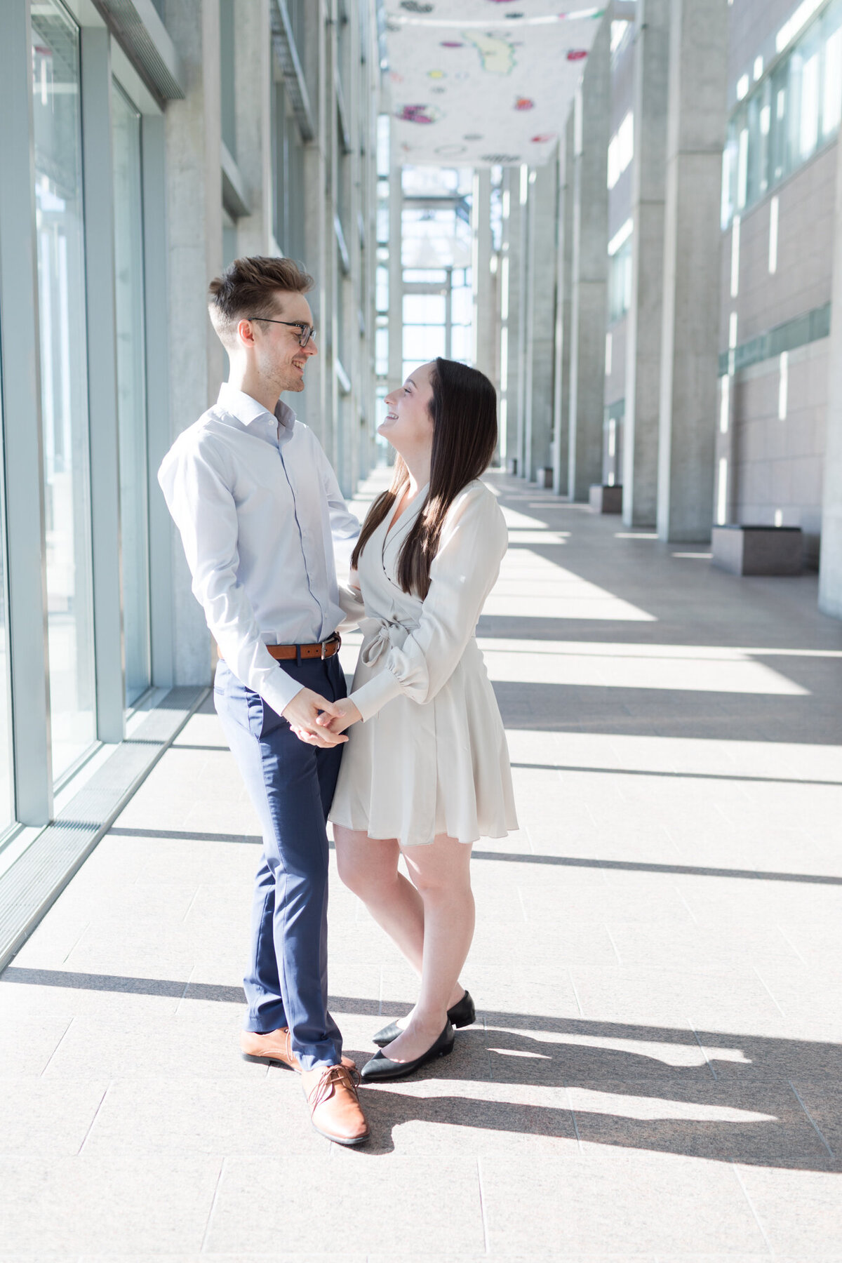 In the grandeur of the National Gallery's great hall, Melissa and Yannick share a tender moment, hands clasped, and eyes locked in a timeless display of love.