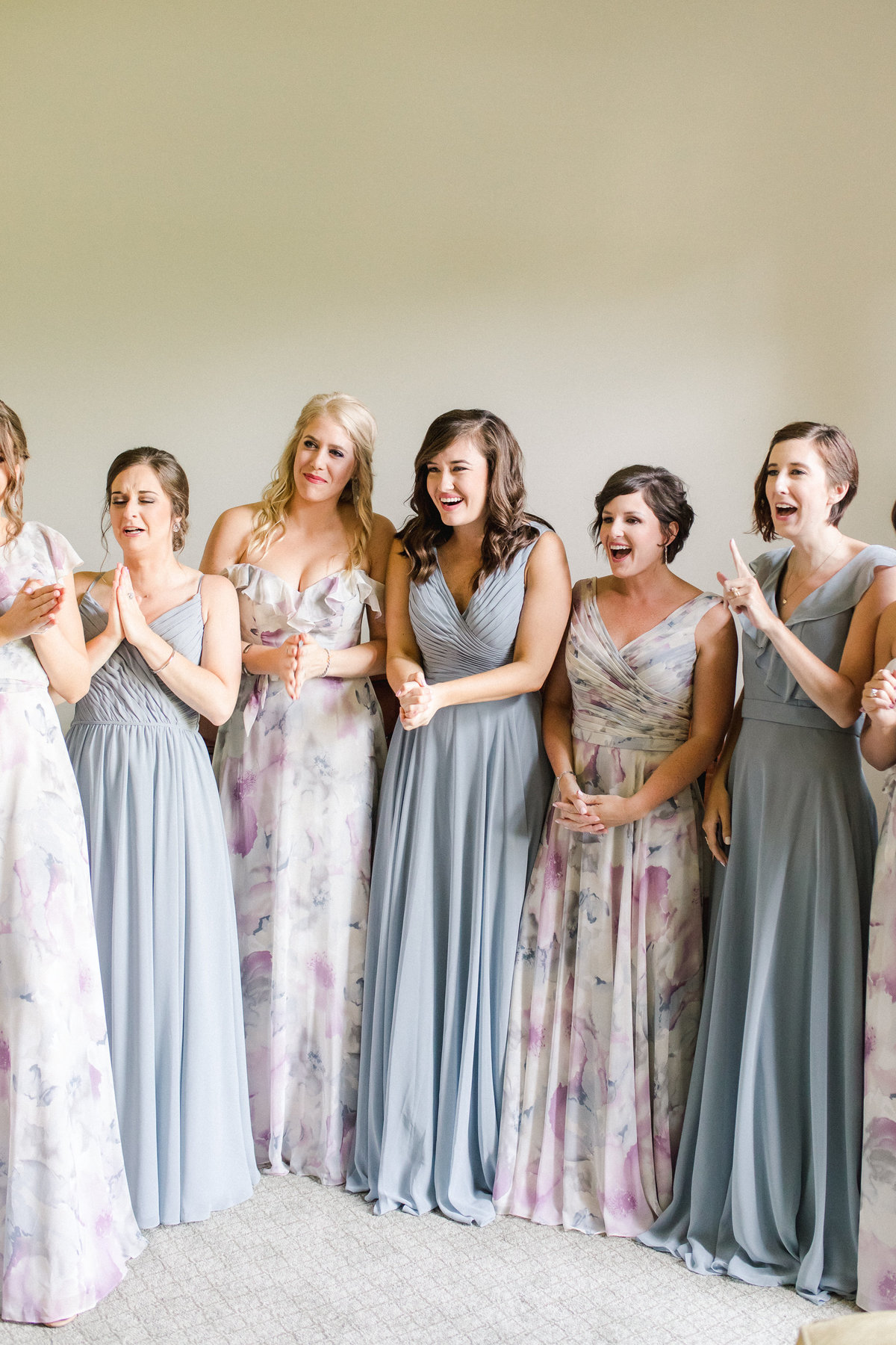 Bridesmaids emotional reaction as they see the bride in her dress for the first time on the wedding day