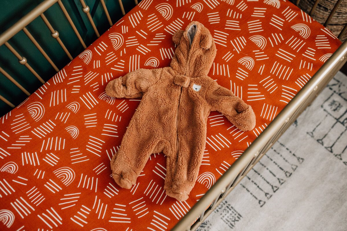 Baby onesie sits in a crib.