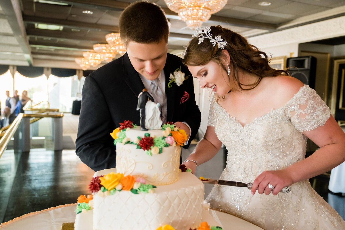 bride and groom cutting their wedding cake during reception at lemont restaurant