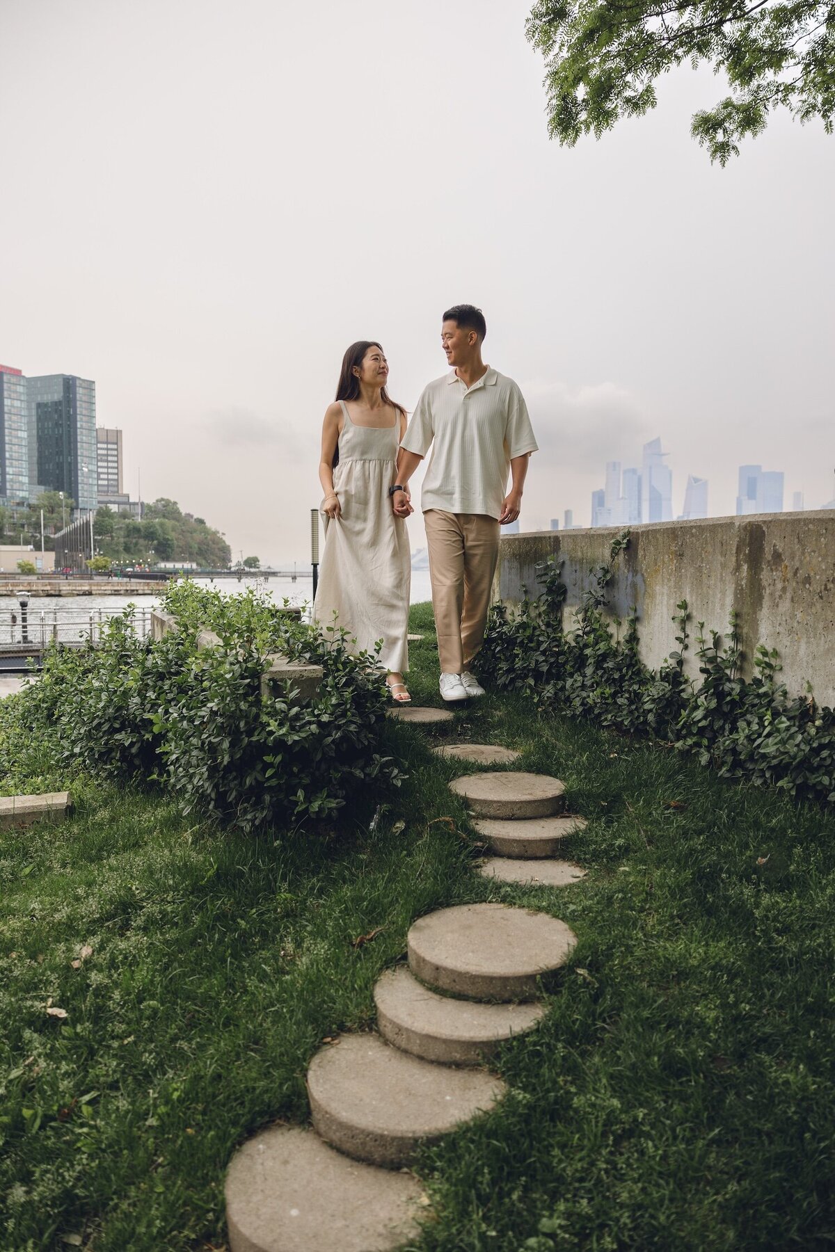 Couple strolling together on stone path with city views