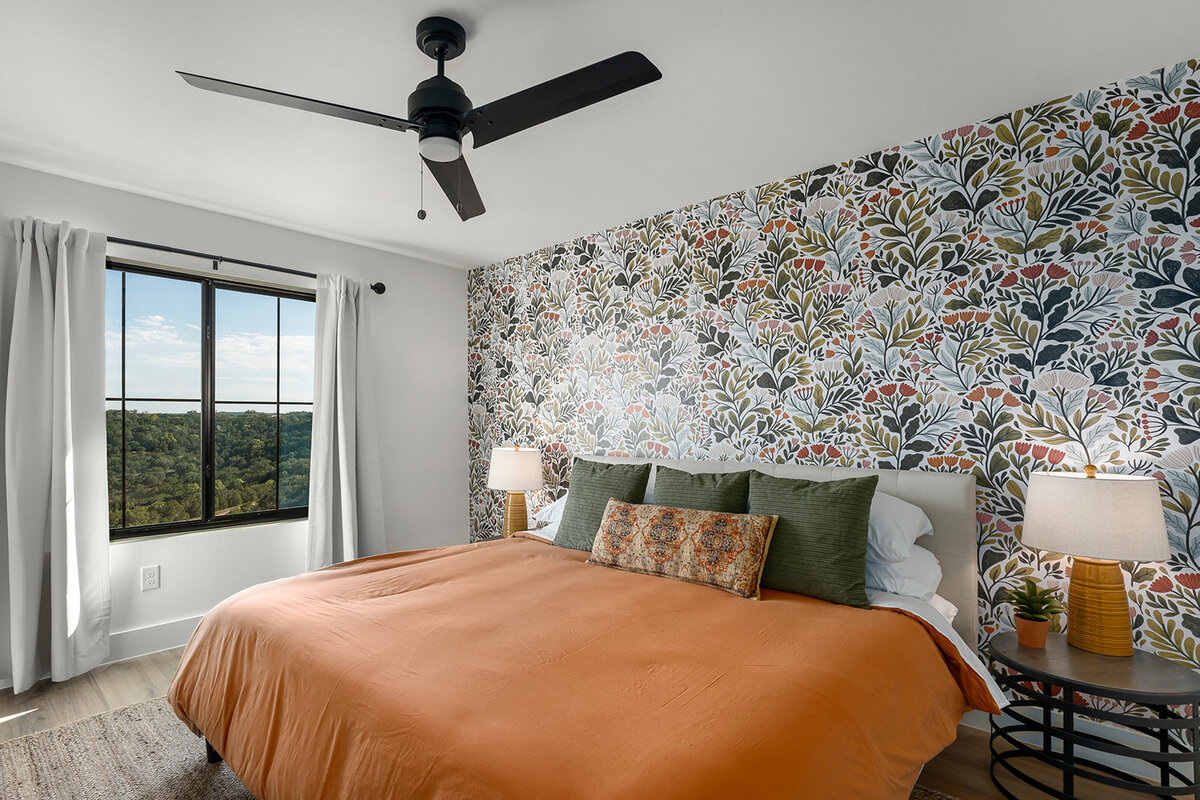 guest bedroom with beautiful view out window and wallpaper feature wall