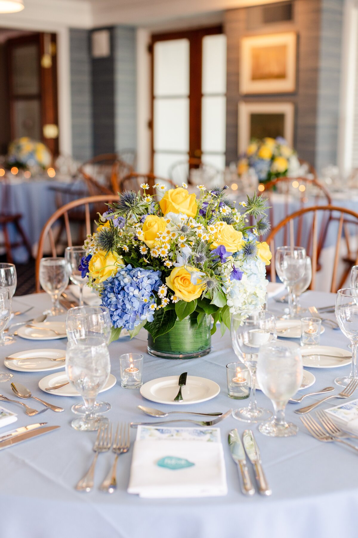 blue and yellow floral arrangement for rehearsal dinner