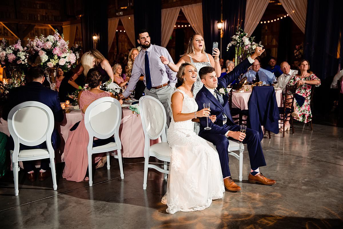 Bride and groom laughing during Maid of Honors toast