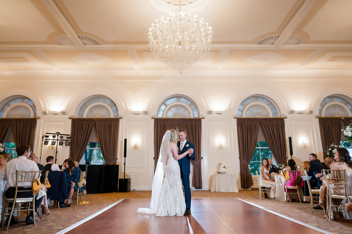 first dance of a wedding couple in the ballroom at university club pittsburgh under crystal chandeliers