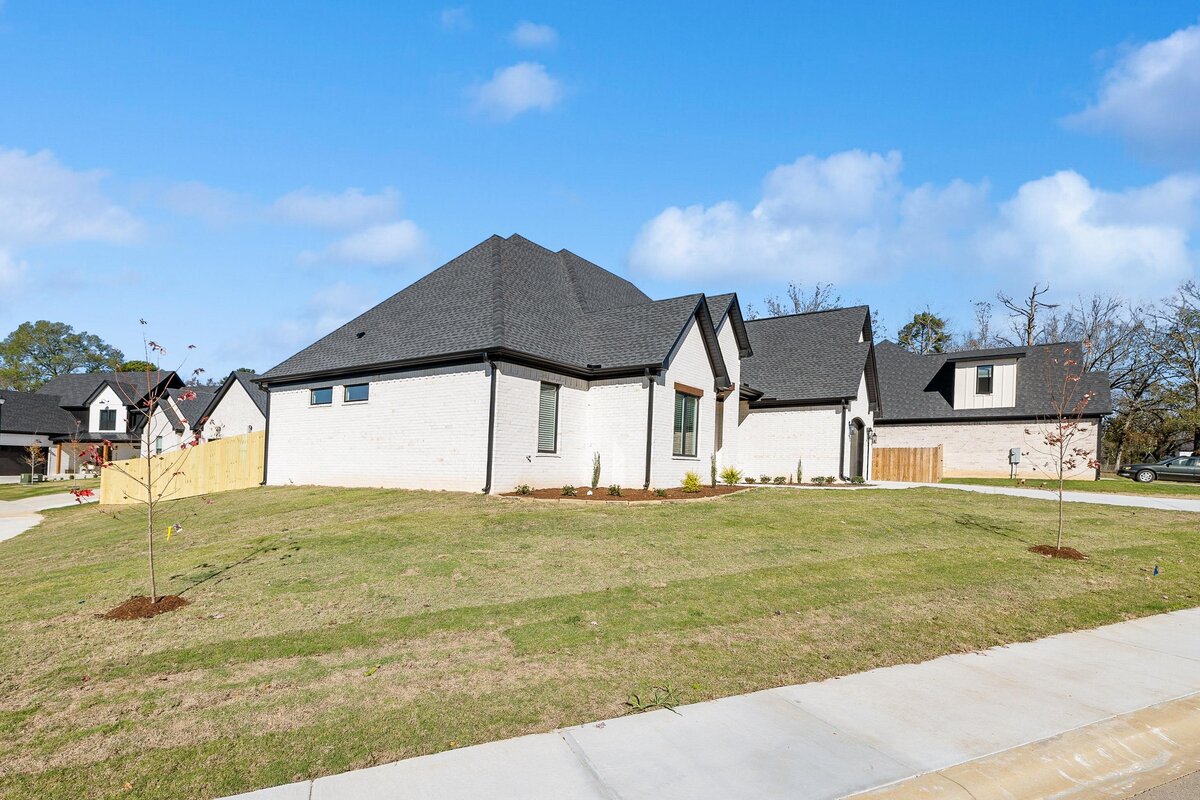 Side view of 6011 Majestic Waters. White house with black trim and wood details.