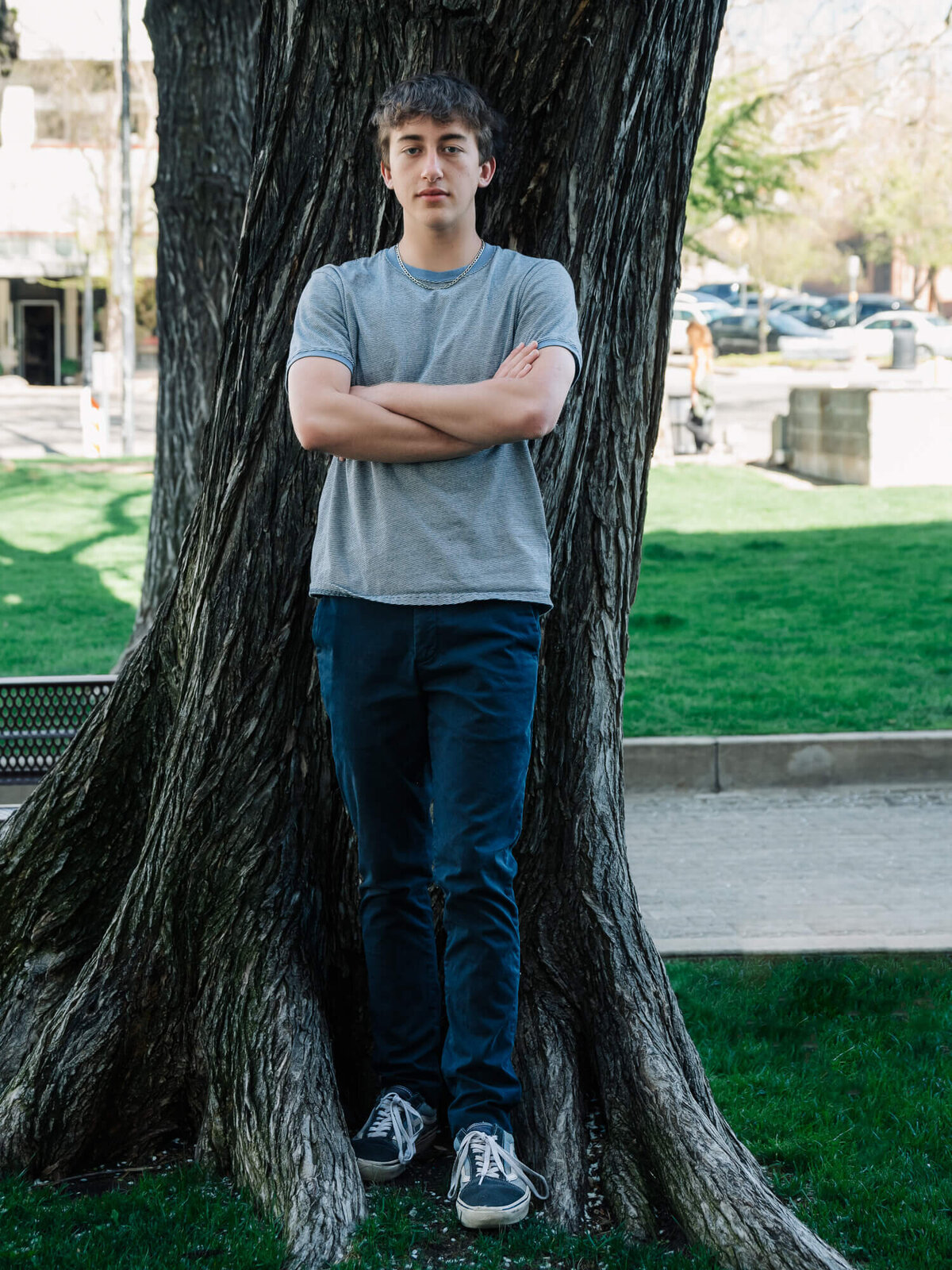 Boy poses against tree on Courthouse Square in Prescott senior photography session