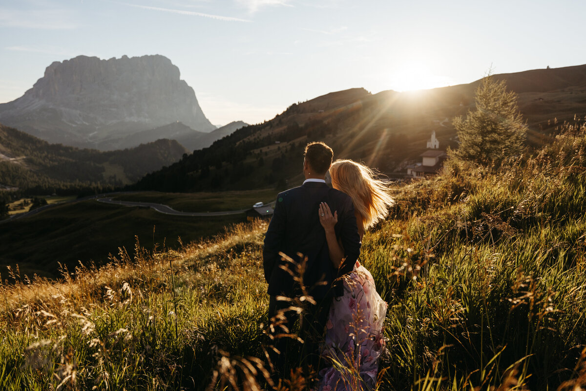 Couple watching sunset over Dolomites mountain range