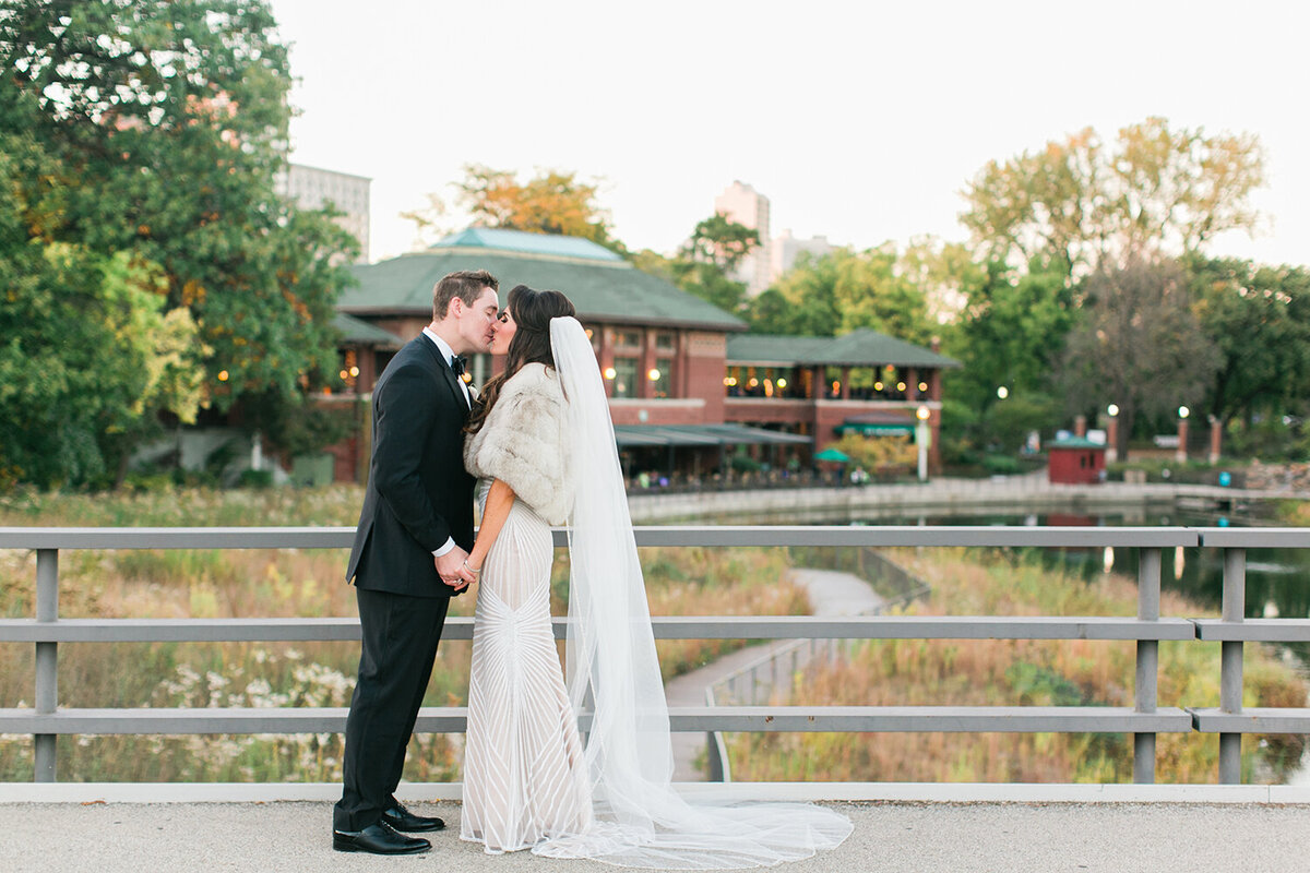 Newlyweds share a kiss outside of their wedding reception.