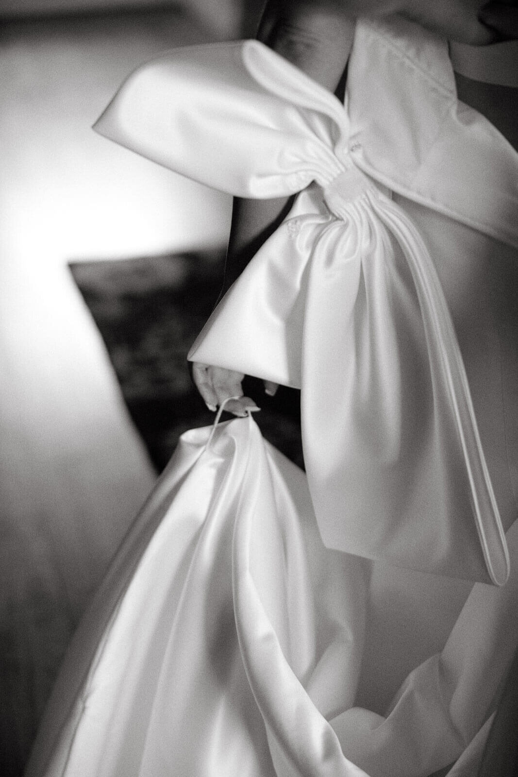A close-up shot of the big white ribbon on the bride's wedding dress at The Lion Rock Farm, CT. Image by Jenny Fu Studio