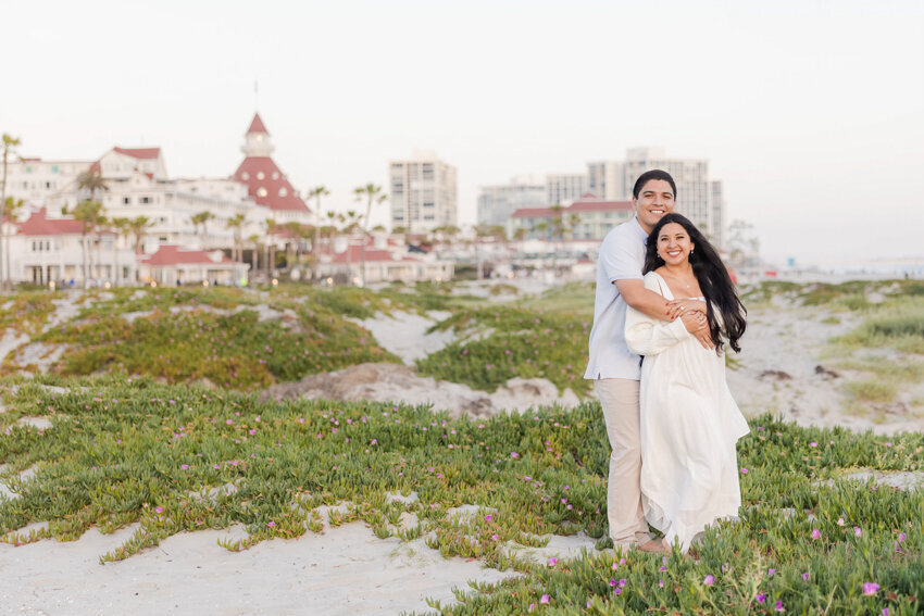 couple-on-dune-with-hotel-del-cornoado-in-background