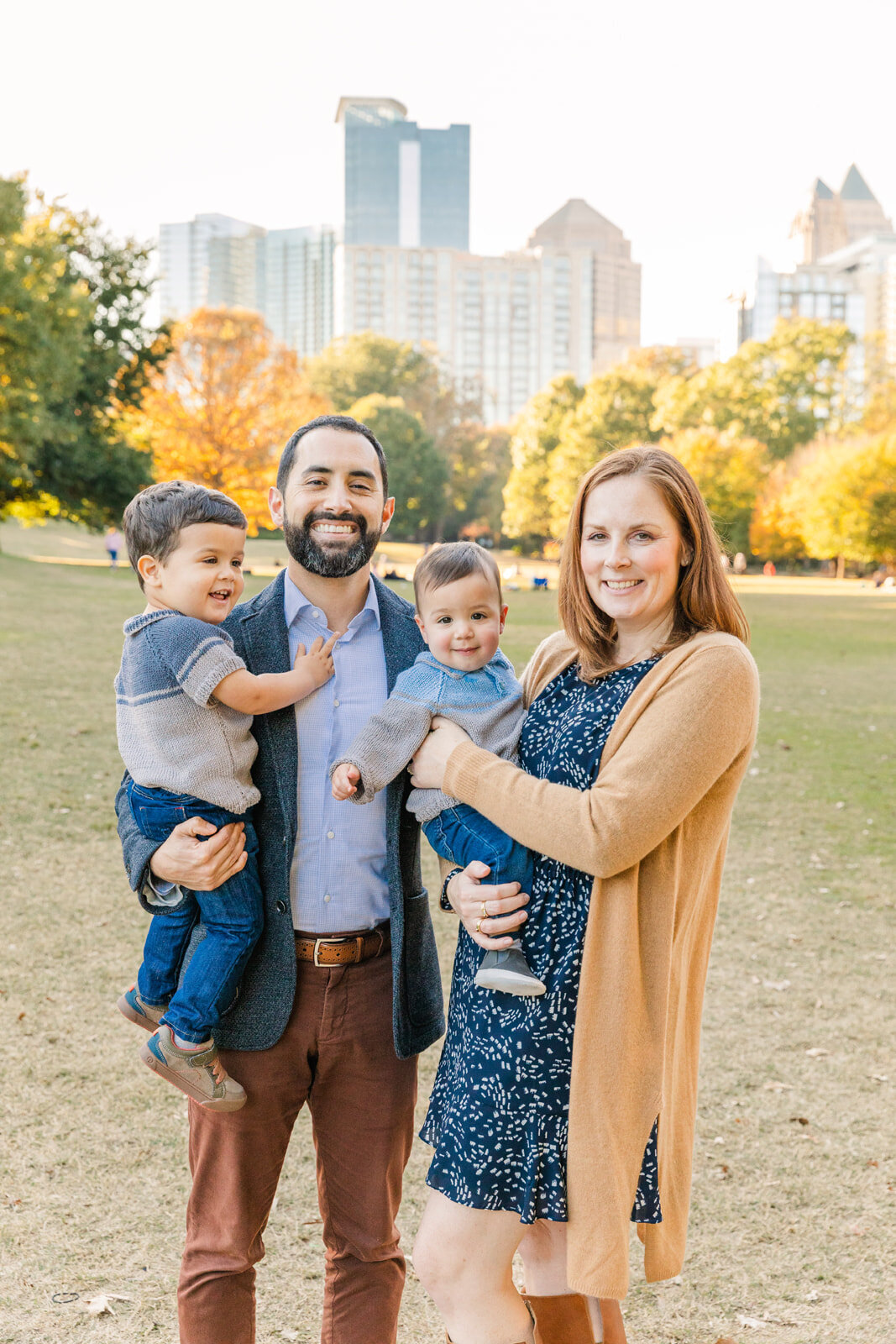 family standing in Piedmont park holding toddlers in Atlanta GA
