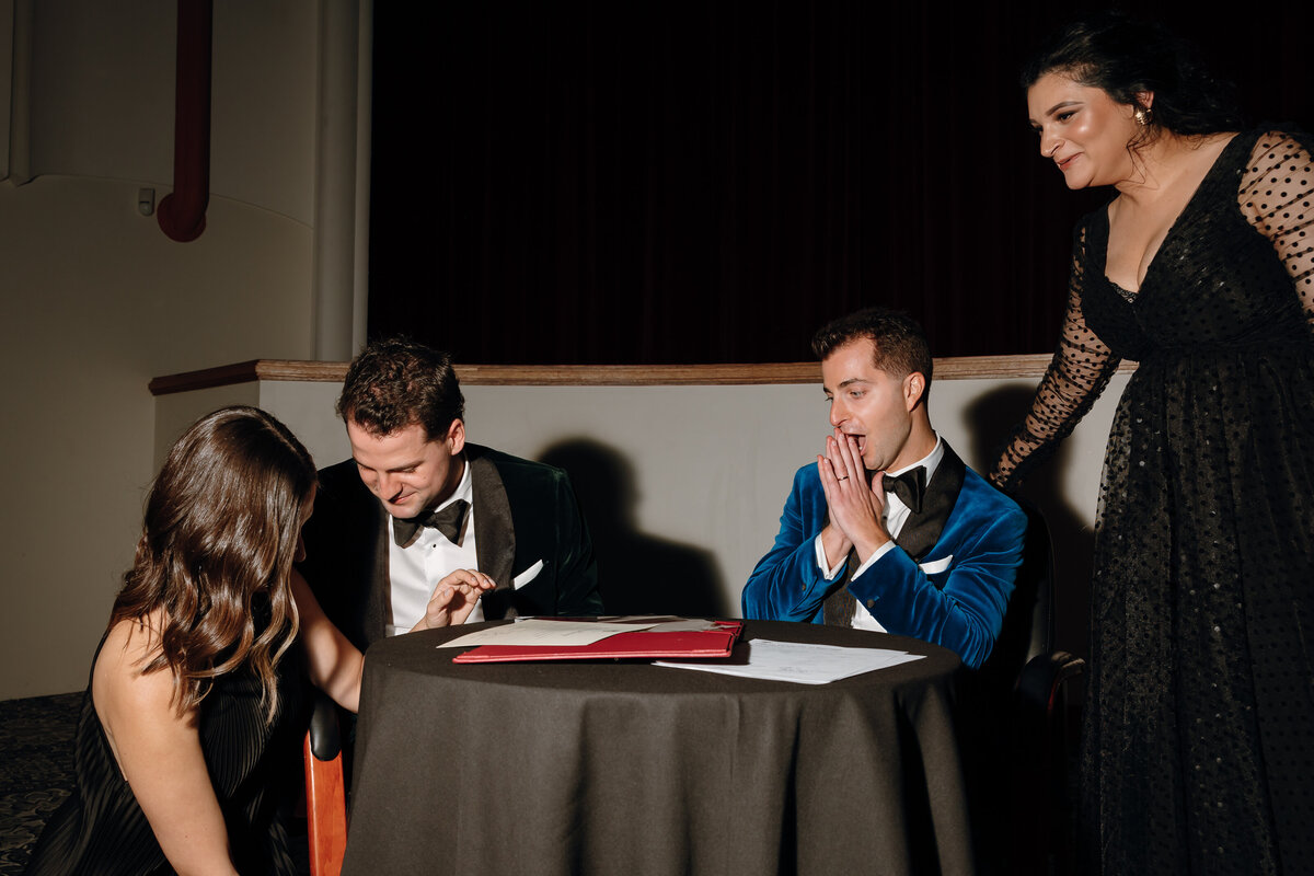 Grooms signing their marriage contract at their regal cinema wedding.