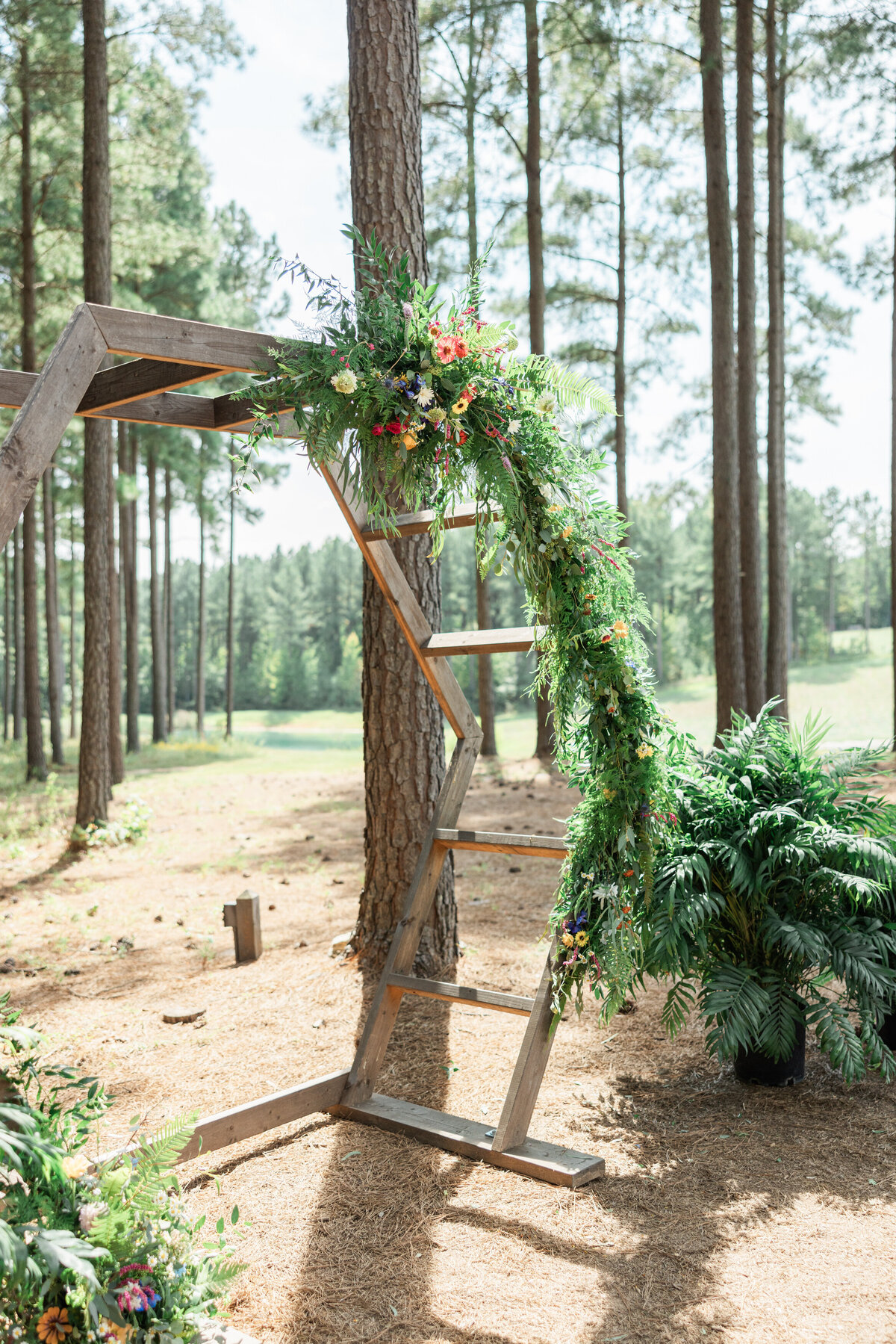 A geometric wedding arch with simple florals on it