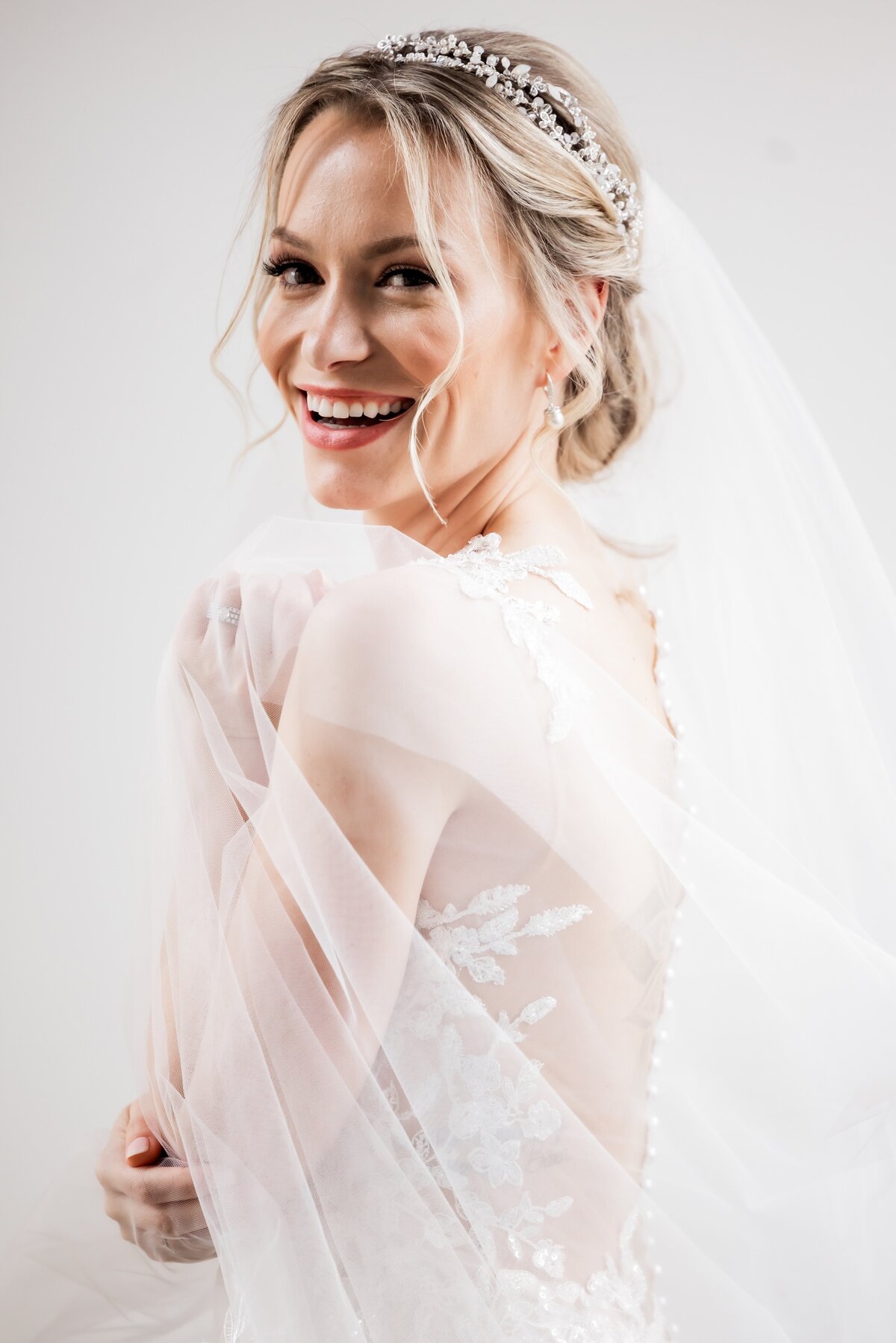 This joyful portrait captures Caro's beaming smile during her special day at The Bell Event Centre. The photograph showcases her happiness and the elegant setting of the venue, emphasizing the bliss and excitement of the wedding celebration. This image serves as beautiful inspiration for future brides and grooms planning their wedding photography, highlighting how a genuine smile can transform a lovely moment into an unforgettable memory.