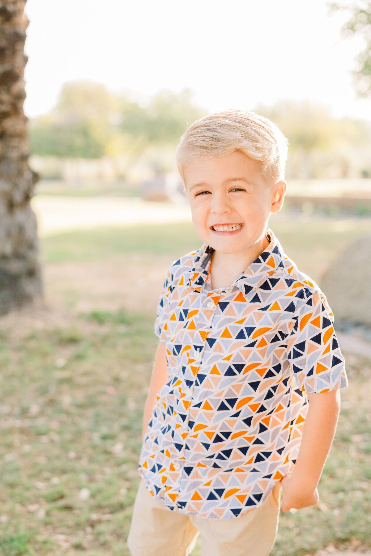 Boy smiles during family photography session during golden hour at Vistancia Mountain Vista Park in Peoria, Arizona.