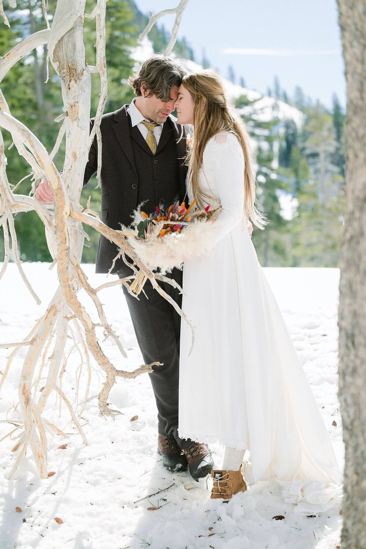 bride and groom share a moment under tree during winter elopement in Tahoe