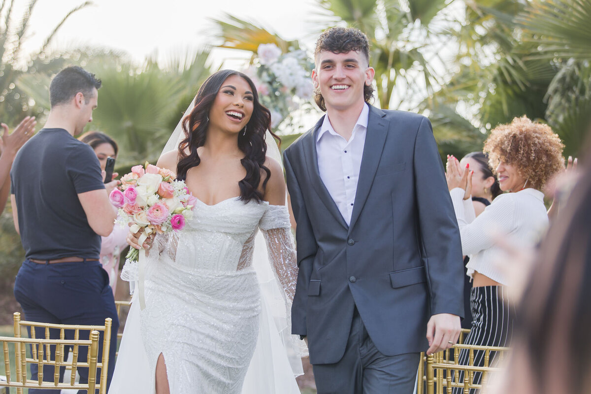 Happy couple celebrating as they walk back down the aisle at after their las vegas micro wedding