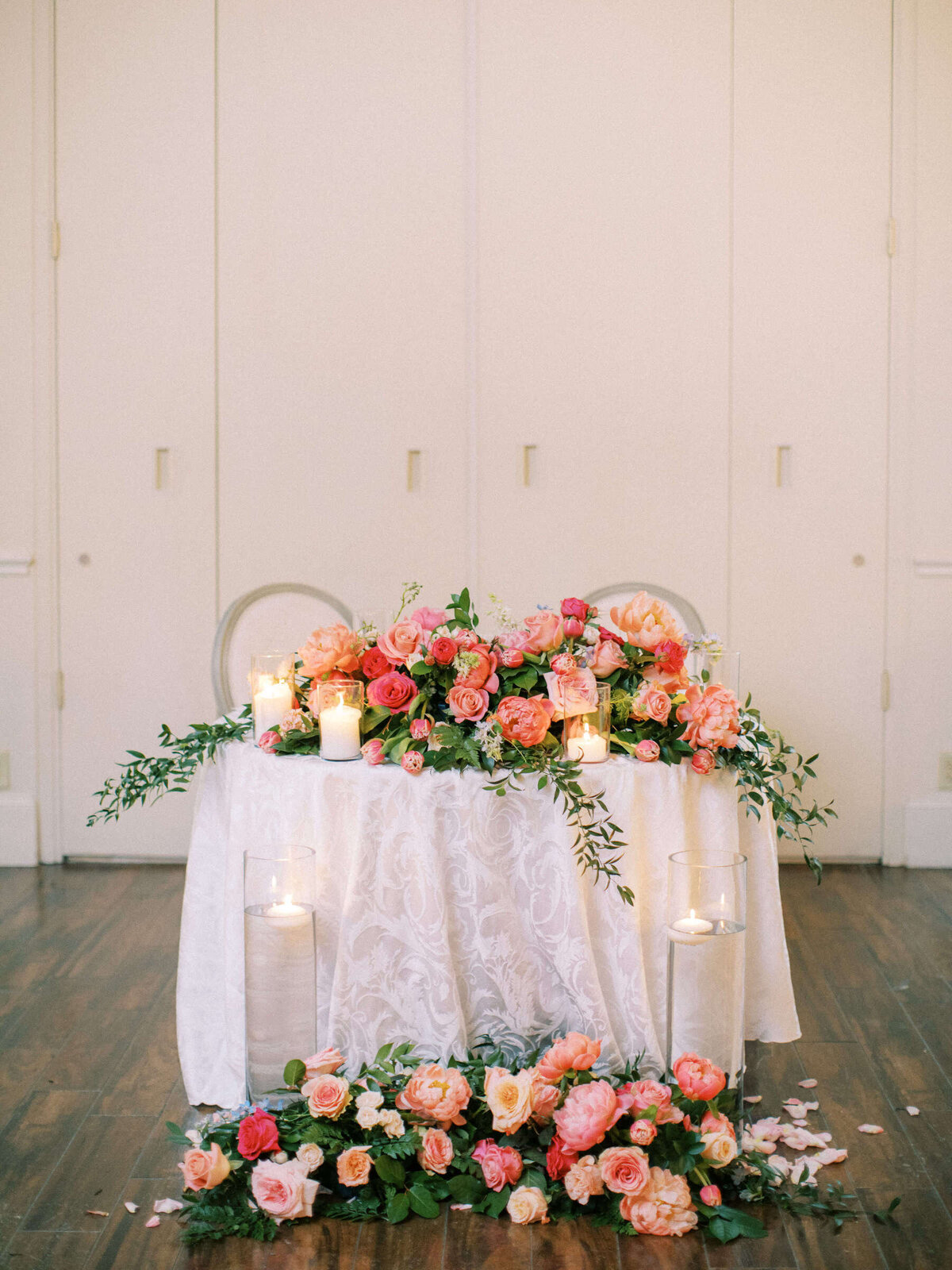 Colorful bridal table spilling with flowers and candles at Ashton Gardens wedding venue
