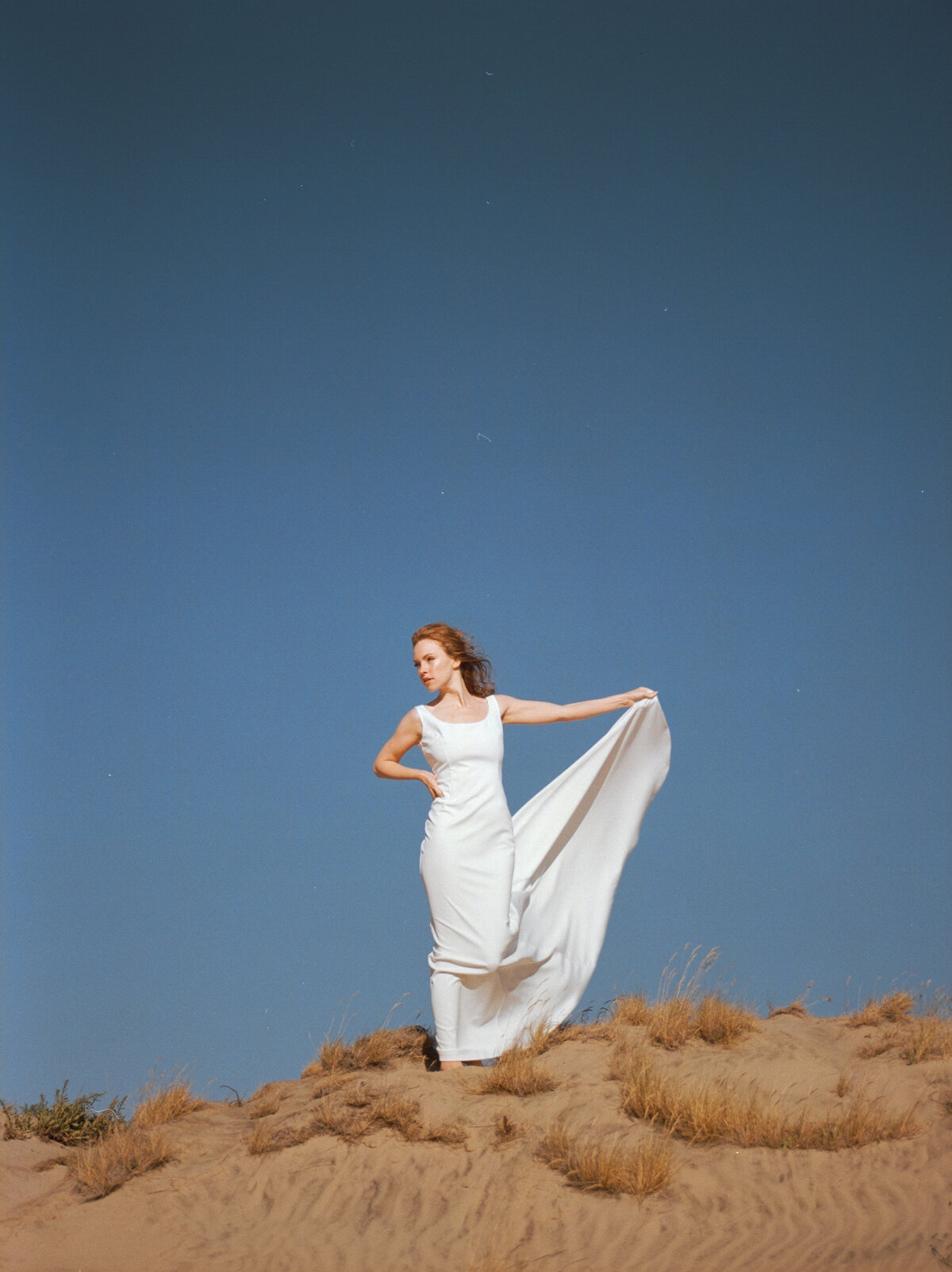 A bride standing on a sand dune