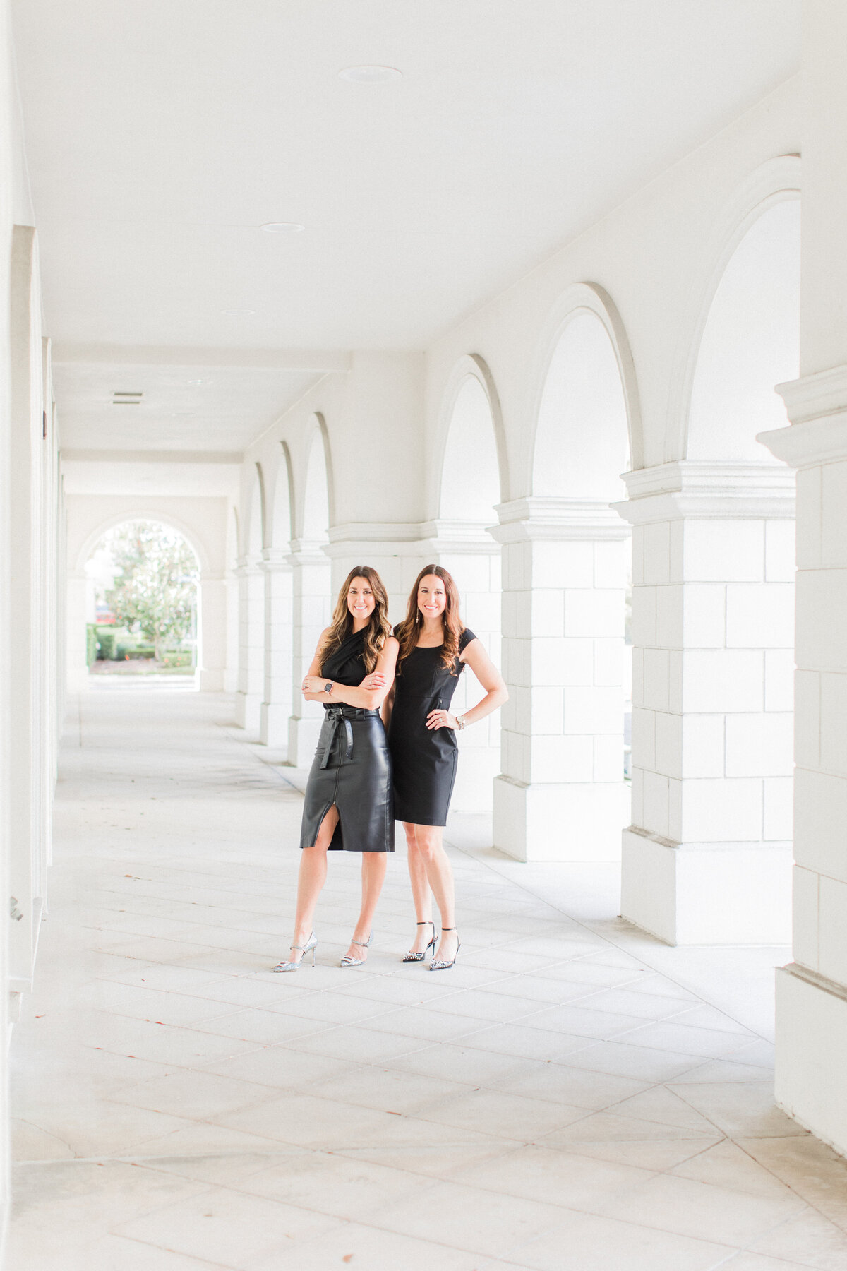 Attorney sisters under white archway by Orlando headshot photographer