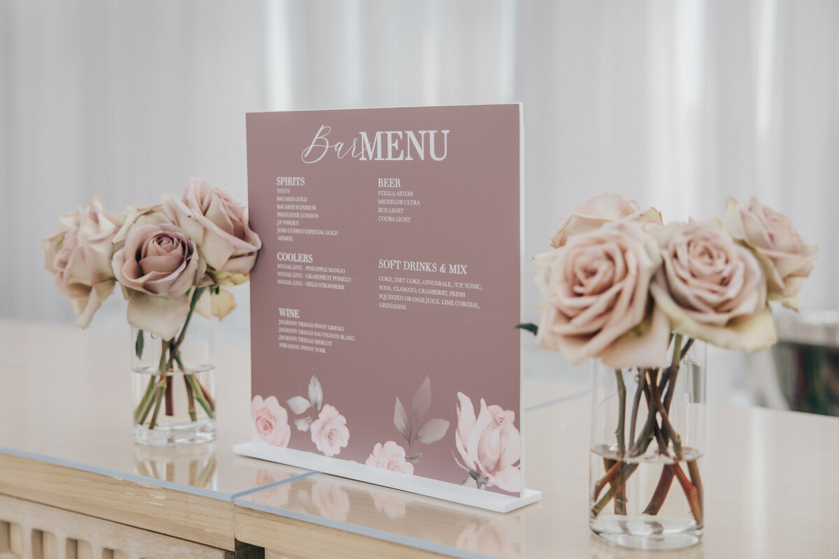 Lavender themed wedding bar menu featuring glasses of blush roses