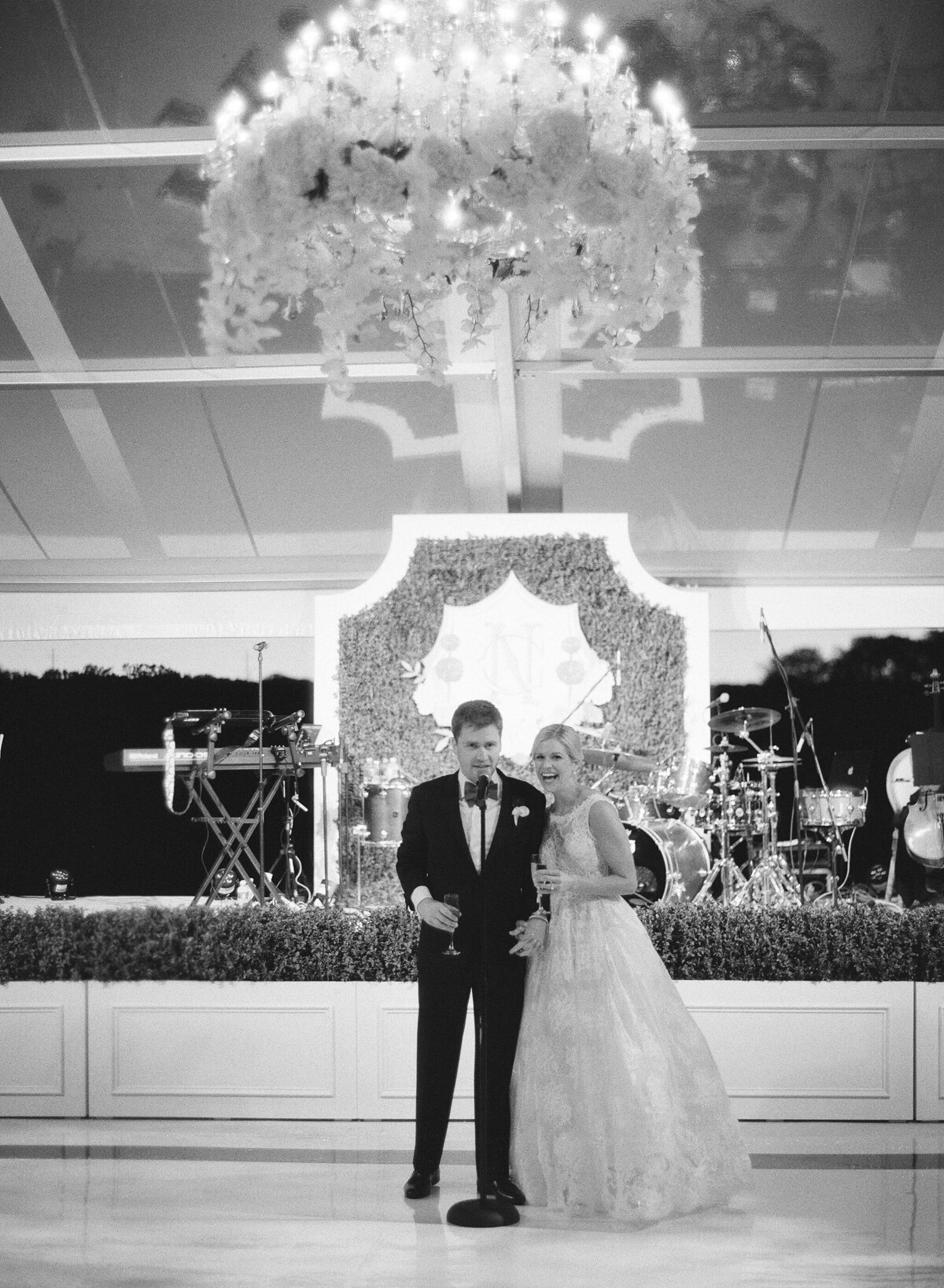 black and white photo of the bride and groom at the microphone on the dance floor. 