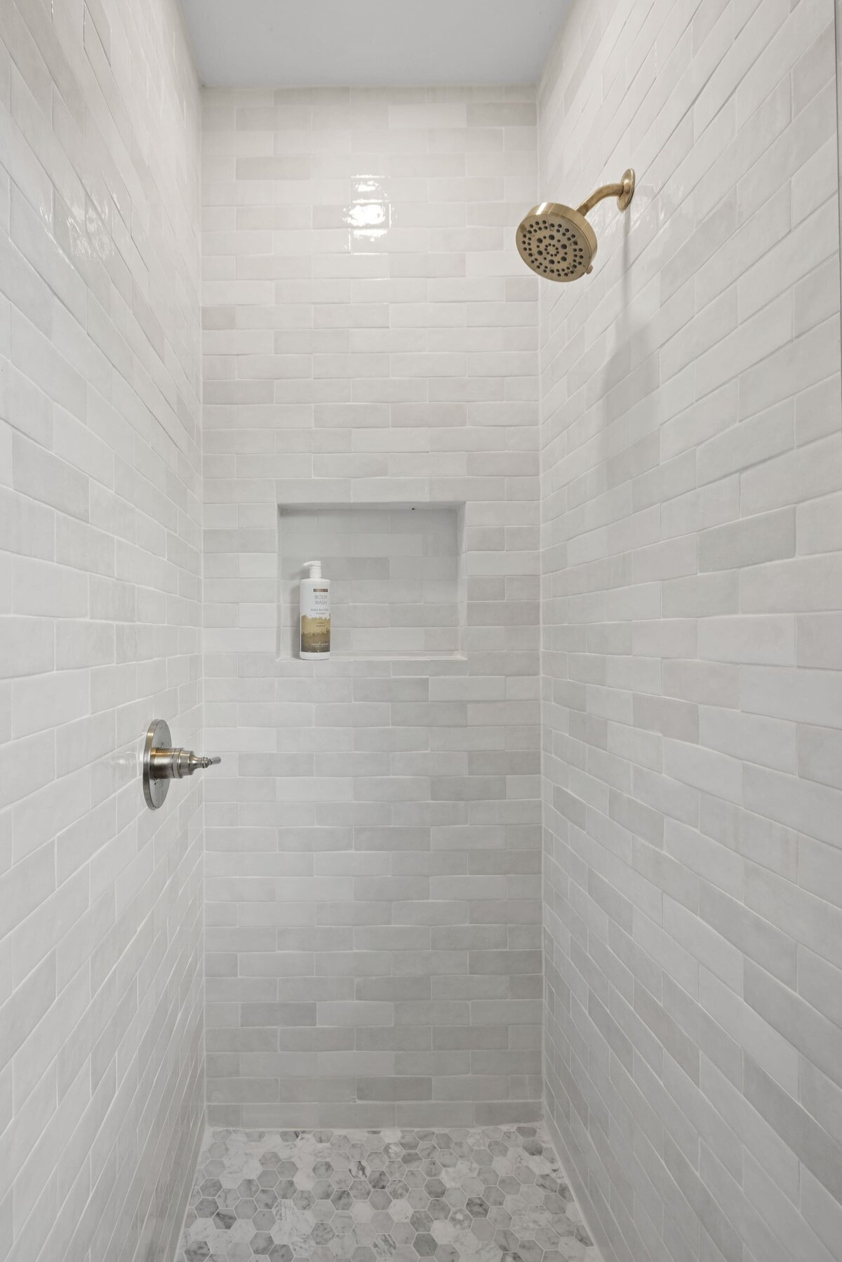 Shower with shiny grey luxury tiles and gold fittings