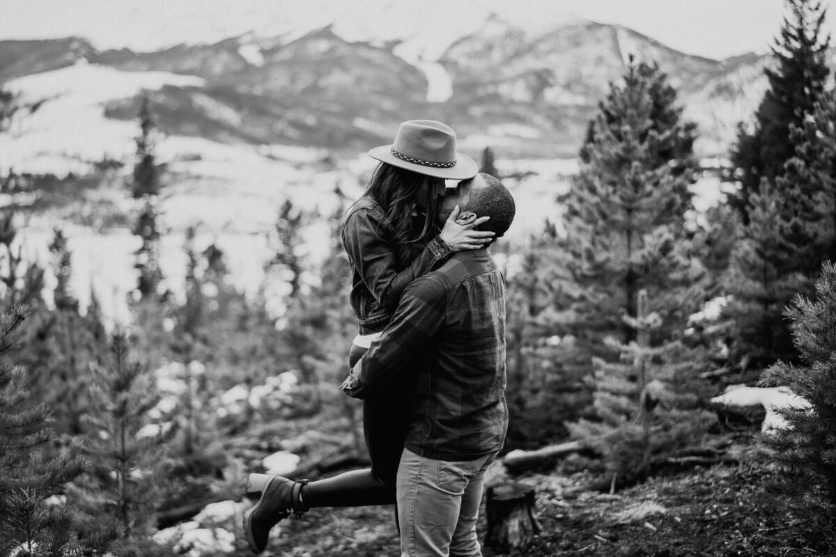 Black and white photo of couple kissing as he lifts her during Sapphire Point engagement.
