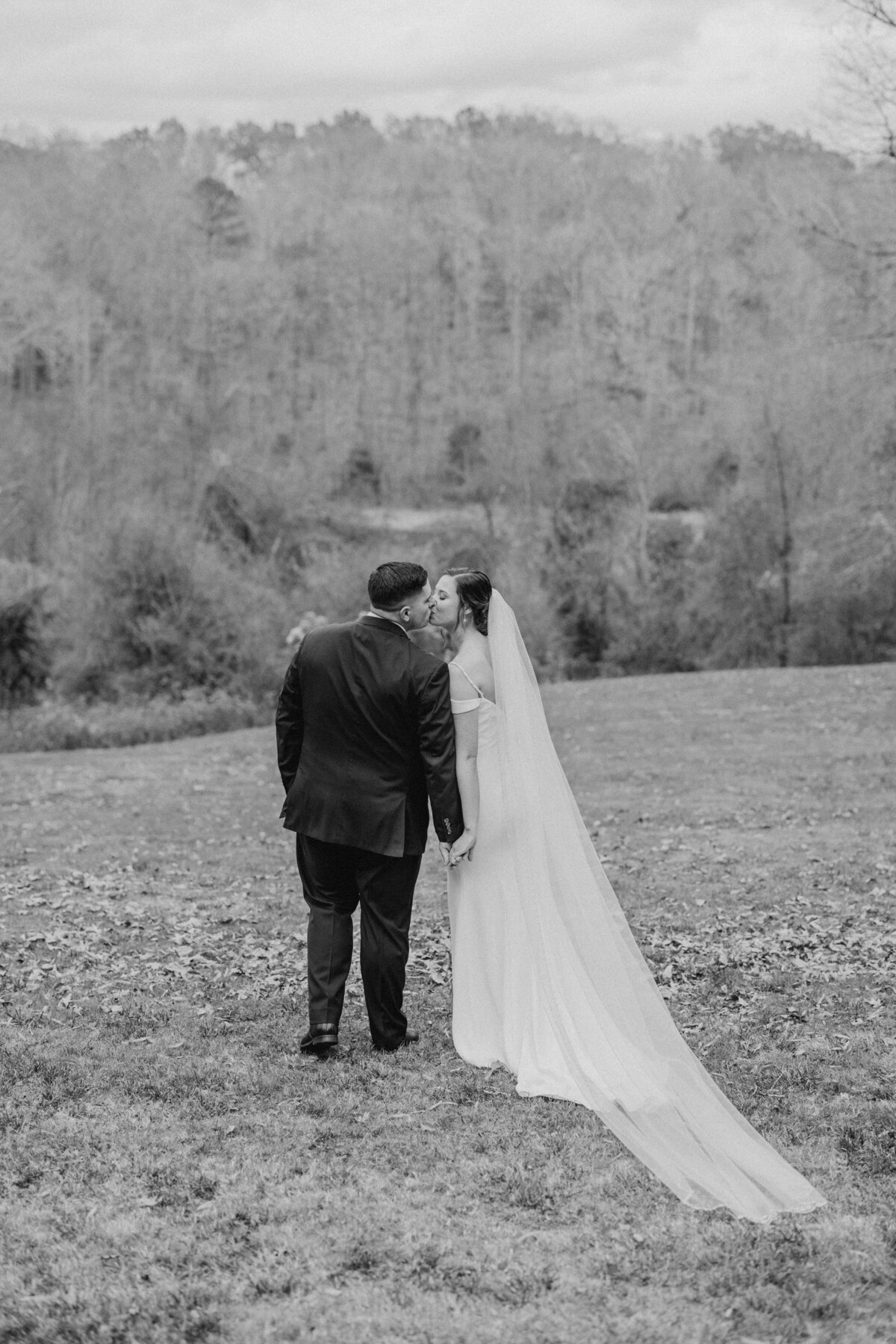 Newlyweds posing with lush tree backdrop, romantic Raleigh wedding photography