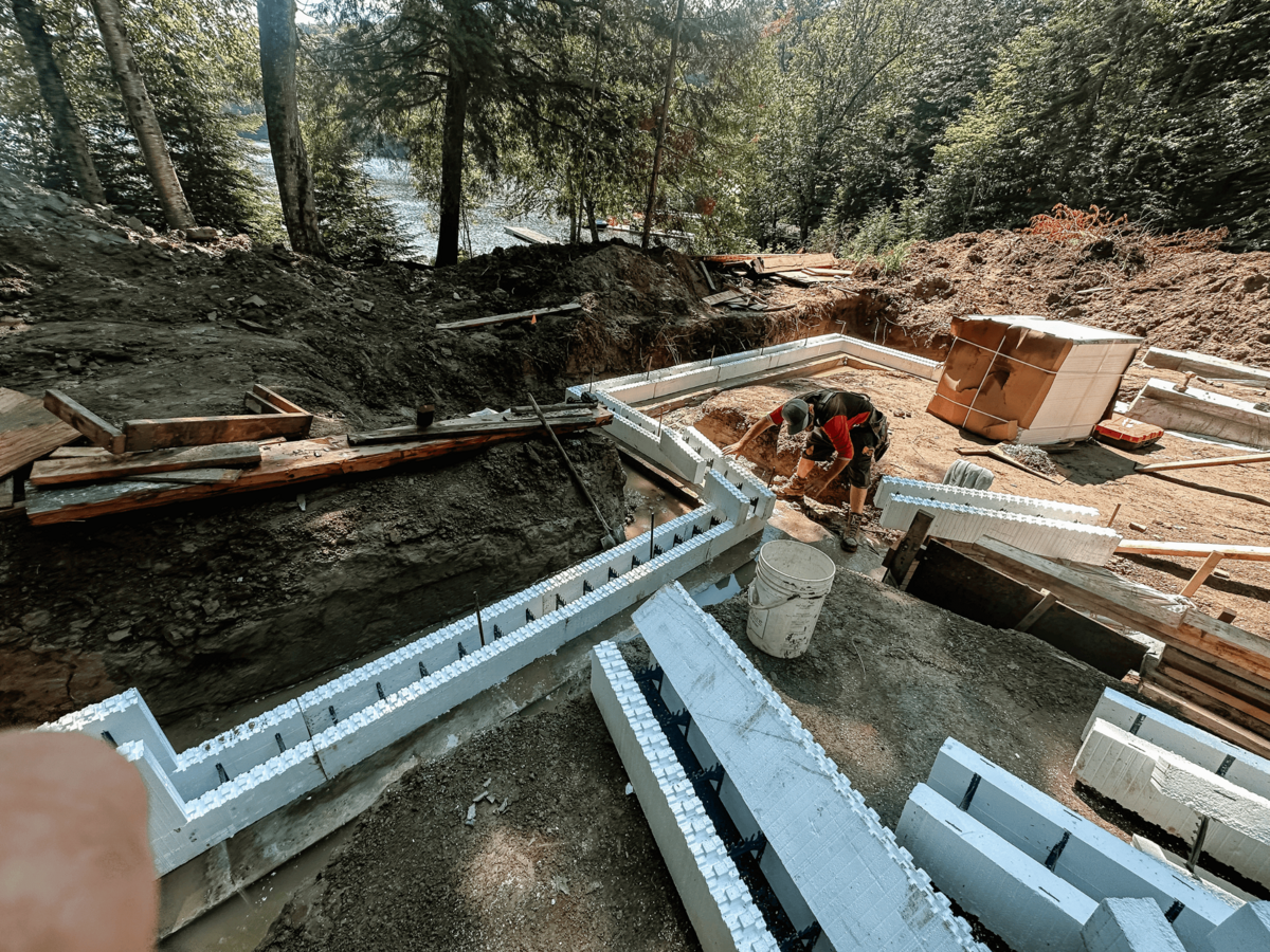 Skilled tradesmen in Haliburton Highlands custom home build handling everything from precise surface grading to expert foundation pouring.