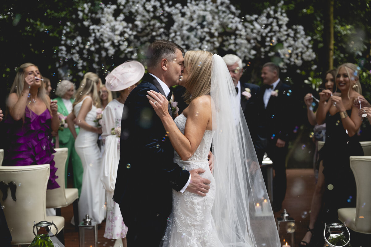 The couple sharing a kiss after their ceremony